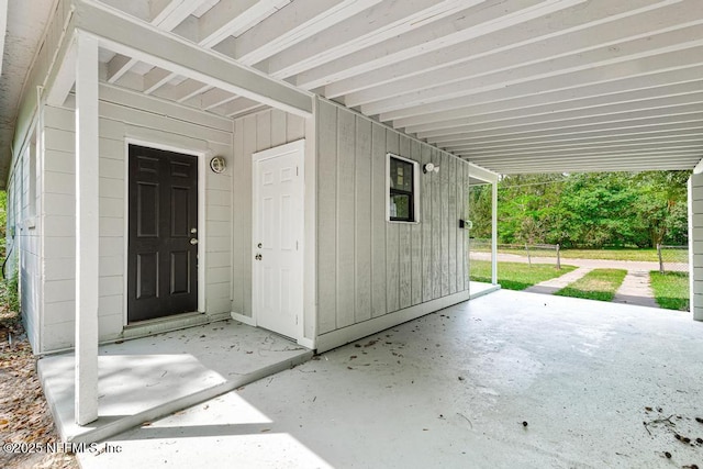 property entrance featuring a carport and a patio area