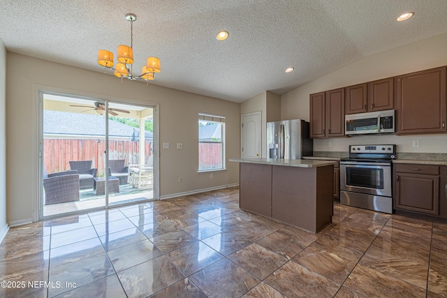 1413 Heather Ct, Saint Augustine, FL 32092 - kitchen with stainless steel appliances, a textured ceiling, a chandelier, a center island, and light countertops