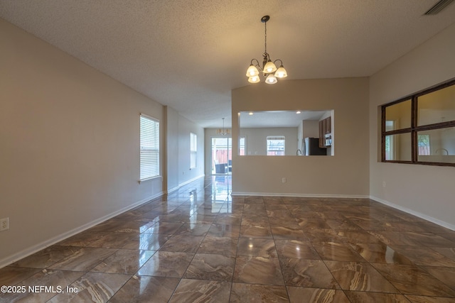 1413 Heather Ct, Saint Augustine, FL 32092 - unfurnished room featuring a chandelier, a textured ceiling, dark marble finish flooring, and baseboards