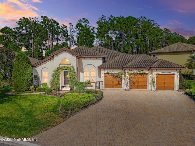 2919 Brettungar Dr, Jacksonville, FL 32224 - mediterranean / spanish home with stucco siding, an attached garage, a tile roof, and decorative driveway