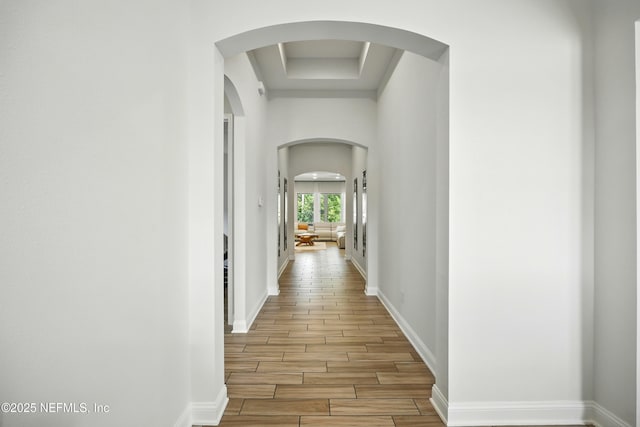 2919 Brettungar Dr, Jacksonville, FL 32224 - hallway featuring arched walkways, wood finish floors, and a tray ceiling