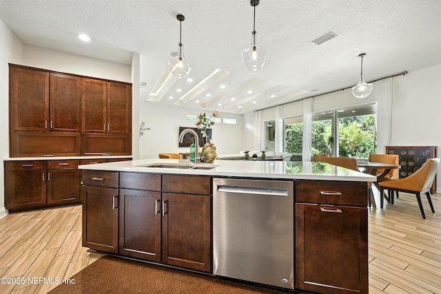 2919 Brettungar Dr, Jacksonville, FL 32224 - kitchen featuring dishwasher, wood tiled floors, light countertops, an island with sink, and hanging light fixtures
