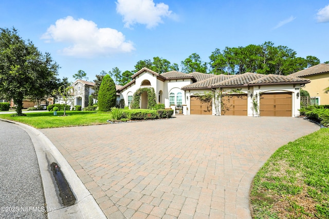 2919 Brettungar Dr, Jacksonville, FL 32224 - mediterranean / spanish house with an attached garage, decorative driveway, a front lawn, stucco siding, and a tile roof