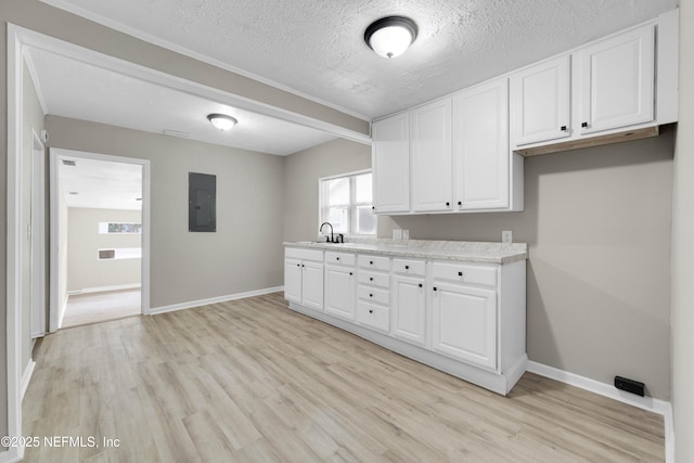 654 Woodbine St, Jacksonville, FL 32206 - washroom featuring electric panel, light wood-style floors, baseboards, a sink, and a textured ceiling