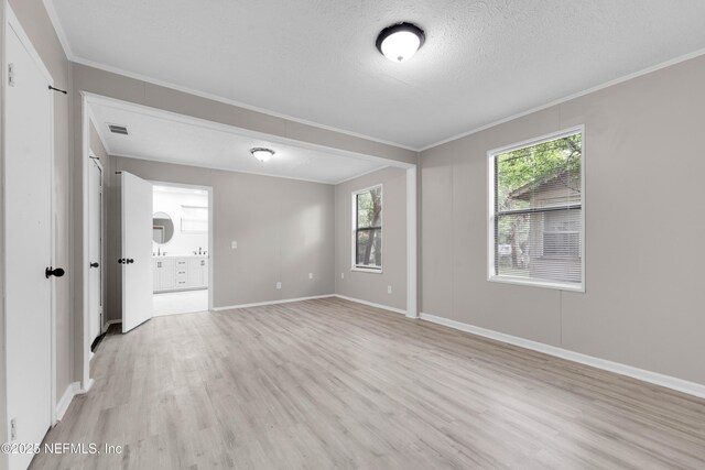 654 Woodbine St, Jacksonville, FL 32206 - spare room featuring ornamental molding, light wood-style floors, baseboards, and a textured ceiling