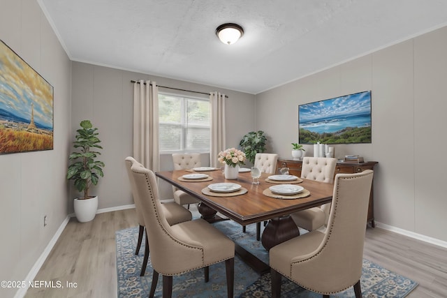 654 Woodbine St, Jacksonville, FL 32206 - dining area with light wood finished floors, crown molding, and baseboards