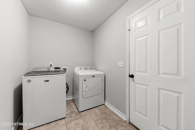 2830 Limestone Ct, Middleburg, FL 32068 - washroom featuring washing machine and dryer, a textured ceiling, light tile patterned flooring, and baseboards