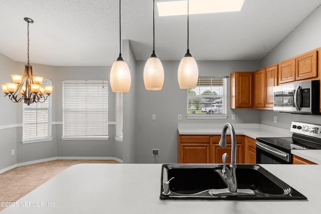 2830 Limestone Ct, Middleburg, FL 32068 - kitchen with stainless steel appliances, a sink, light countertops, a chandelier, and pendant lighting