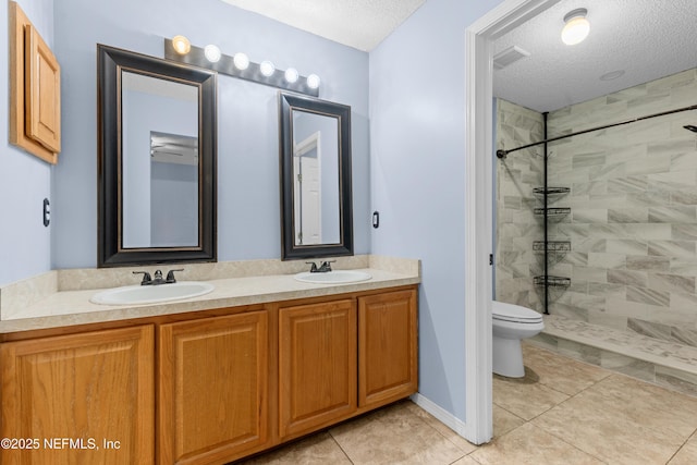 2830 Limestone Ct, Middleburg, FL 32068 - bathroom with a textured ceiling, toilet, double vanity, a tile shower, and tile patterned flooring