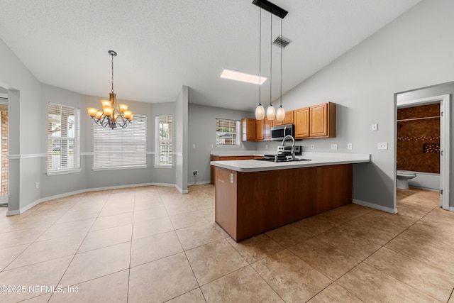 2830 Limestone Ct, Middleburg, FL 32068 - kitchen with stainless steel microwave, a chandelier, a peninsula, light countertops, and light tile patterned floors