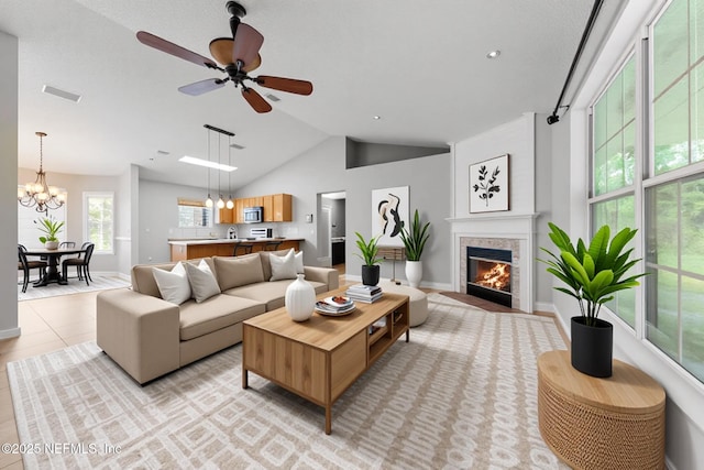 2830 Limestone Ct, Middleburg, FL 32068 - living area featuring a fireplace with flush hearth, ceiling fan, a chandelier, baseboards, and high vaulted ceiling