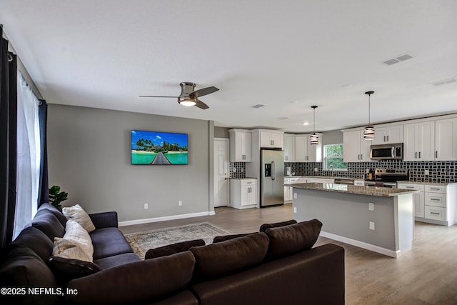 1573 Aletha Dr, Jacksonville, FL 32211 - living area featuring a ceiling fan, baseboards, and light wood-type flooring