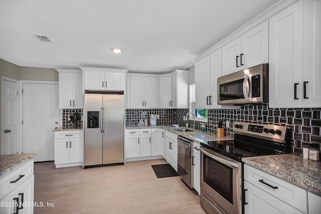 1573 Aletha Dr, Jacksonville, FL 32211 - kitchen with stainless steel appliances, white cabinetry, backsplash, and recessed lighting