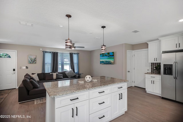 1573 Aletha Dr, Jacksonville, FL 32211 - kitchen with stainless steel fridge, wood finished floors, pendant lighting, a textured ceiling, and light stone countertops
