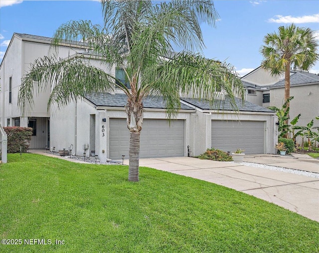 view of front of house with driveway, a front lawn, stucco siding, and a garage