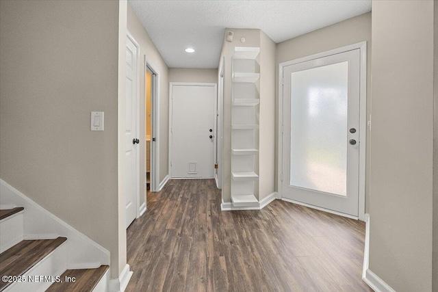foyer featuring wood finished floors, baseboards, stairs, and recessed lighting
