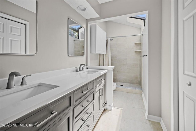 bathroom with toilet, a stall shower, double vanity, baseboards, and tile patterned floors