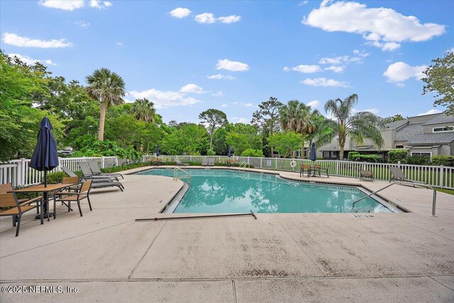 community pool featuring a patio and fence