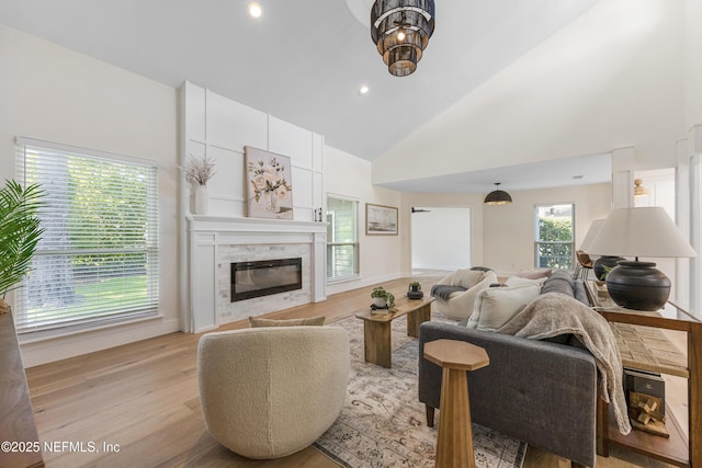 5105 Otter Creek Dr, Ponte Vedra Beach, FL 32082 - living area with a glass covered fireplace, light wood-type flooring, high vaulted ceiling, recessed lighting, and baseboards