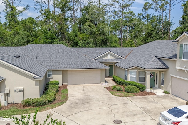 2120 Stone Creek Dr Unit E, Fleming Island, FL 32003 - view of front of home featuring stucco siding, a garage, driveway, and a shingled roof