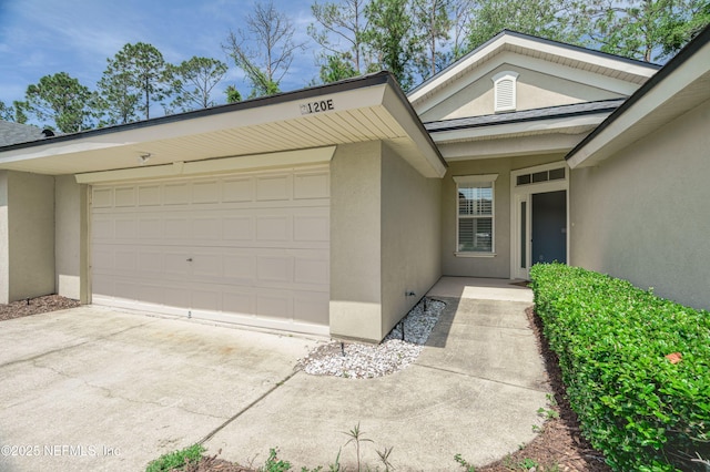 2120 Stone Creek Dr Unit E, Fleming Island, FL 32003 - doorway to property featuring stucco siding, an attached garage, and concrete driveway