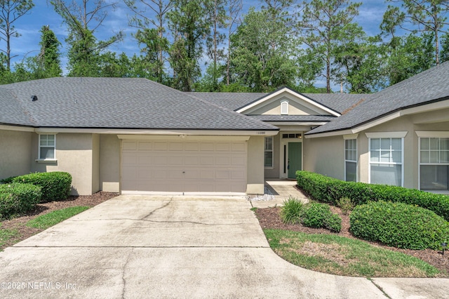 2120 Stone Creek Dr Unit E, Fleming Island, FL 32003 - ranch-style home with stucco siding, a garage, roof with shingles, and driveway