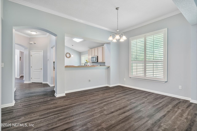 2120 Stone Creek Dr Unit E, Fleming Island, FL 32003 - kitchen with stainless steel microwave, dark wood finished floors, ornamental molding, baseboards, and arched walkways
