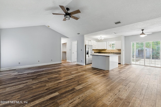 12613 Deeder Ln, Jacksonville, FL 32258 - unfurnished living room featuring a ceiling fan, wood finished floors, a textured ceiling, baseboards, and lofted ceiling