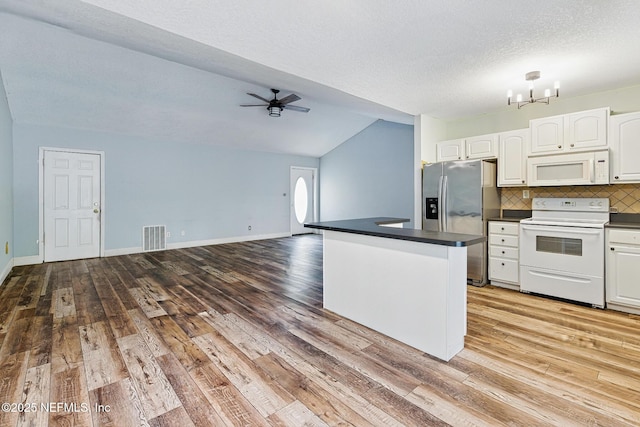 12613 Deeder Ln, Jacksonville, FL 32258 - kitchen featuring white appliances, dark countertops, white cabinets, vaulted ceiling, and wood finished floors