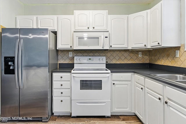 12613 Deeder Ln, Jacksonville, FL 32258 - kitchen featuring white appliances, dark countertops, white cabinets, and wood finished floors