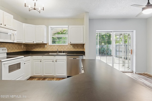 12613 Deeder Ln, Jacksonville, FL 32258 - kitchen featuring white appliances, dark countertops, a sink, light wood finished floors, and a textured ceiling