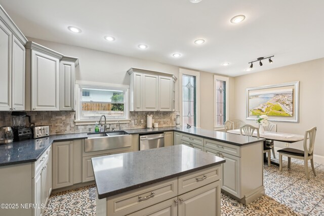 16 May St, Saint Augustine, FL 32084 - kitchen featuring a sink, stainless steel dishwasher, a peninsula, backsplash, and a kitchen island
