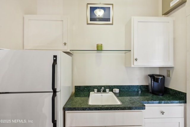 16 May St, Saint Augustine, FL 32084 - kitchen with freestanding refrigerator, a sink, white cabinets, and dark countertops