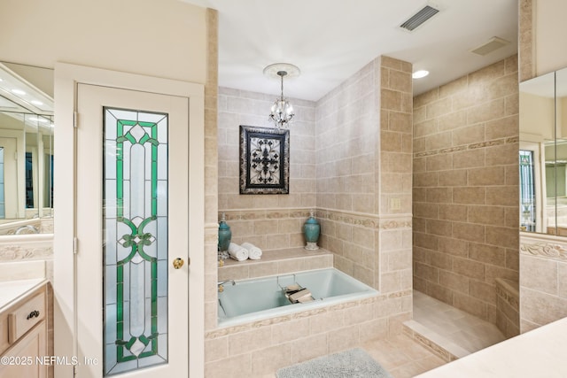 16 May St, Saint Augustine, FL 32084 - full bathroom with tile walls, vanity, a garden tub, and a chandelier