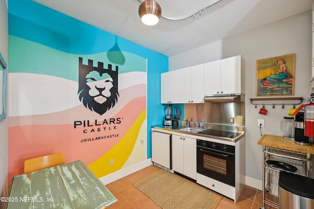 16 May St, Saint Augustine, FL 32084 - kitchen with black appliances, under cabinet range hood, white cabinetry, and light tile patterned flooring
