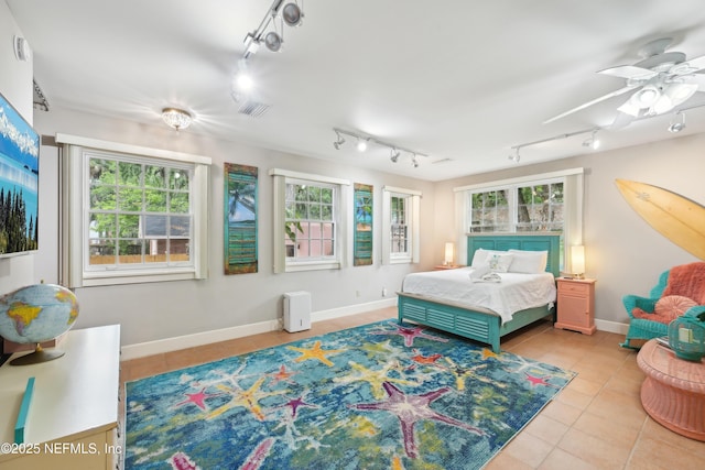 16 May St, Saint Augustine, FL 32084 - tiled bedroom featuring rail lighting and baseboards