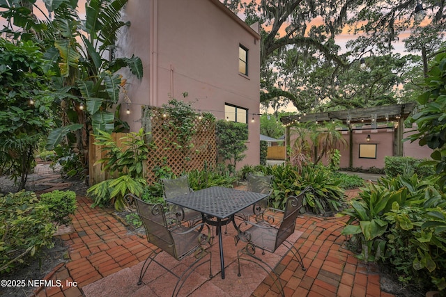 16 May St, Saint Augustine, FL 32084 - patio terrace at dusk with a pergola and outdoor dining area