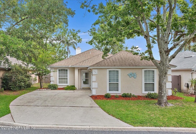 view of front of house featuring stucco siding, a front lawn, a chimney, and roof with shingles