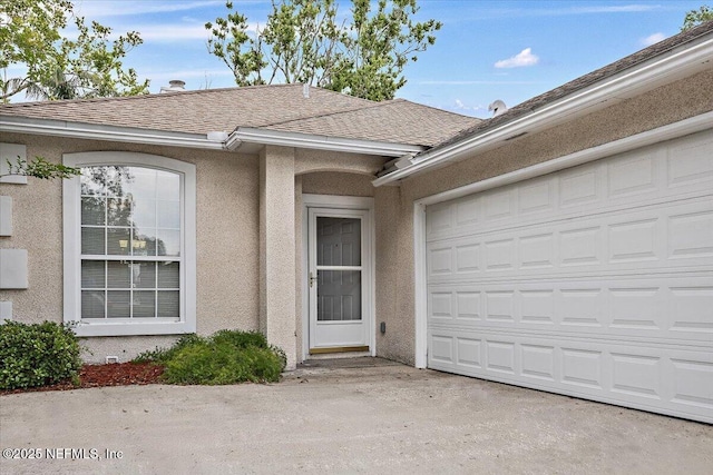 property entrance featuring stucco siding, roof with shingles, and a garage