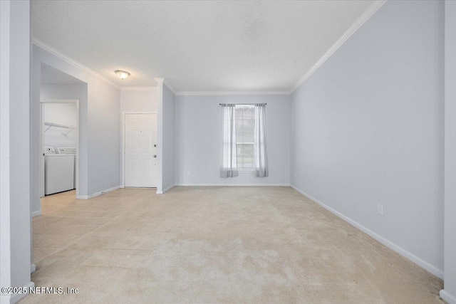 spare room with crown molding, baseboards, light carpet, a textured ceiling, and separate washer and dryer
