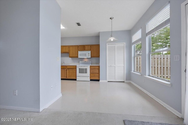 kitchen with white appliances, baseboards, light countertops, and brown cabinetry
