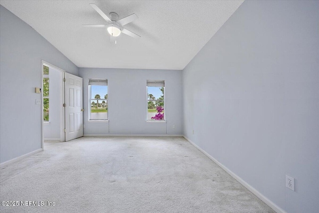 empty room featuring a textured ceiling, ceiling fan, healthy amount of natural light, and carpet