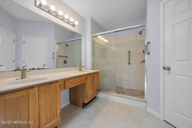 bathroom with a stall shower, tile patterned flooring, double vanity, and vaulted ceiling