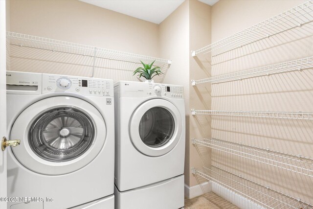 425 N Ocean Grande Dr Unit 205, Ponte Vedra Beach, FL 32082 - laundry room featuring washing machine and clothes dryer, light tile patterned flooring, and baseboards