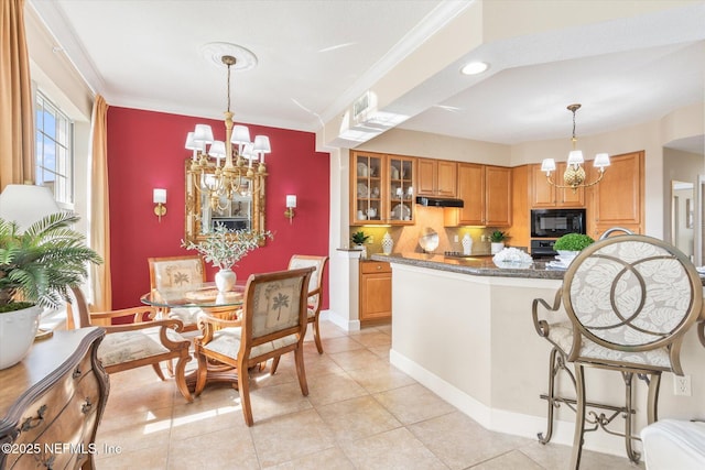 425 N Ocean Grande Dr Unit 205, Ponte Vedra Beach, FL 32082 - kitchen featuring a chandelier, black microwave, under cabinet range hood, glass insert cabinets, and crown molding