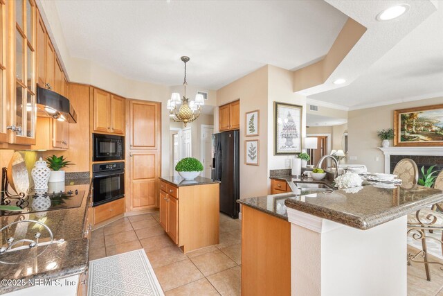 425 N Ocean Grande Dr Unit 205, Ponte Vedra Beach, FL 32082 - kitchen featuring black appliances, a sink, under cabinet range hood, a kitchen island, and dark stone countertops