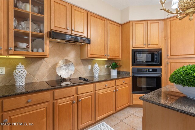 425 N Ocean Grande Dr Unit 205, Ponte Vedra Beach, FL 32082 - kitchen featuring black appliances, under cabinet range hood, dark stone counters, and tasteful backsplash