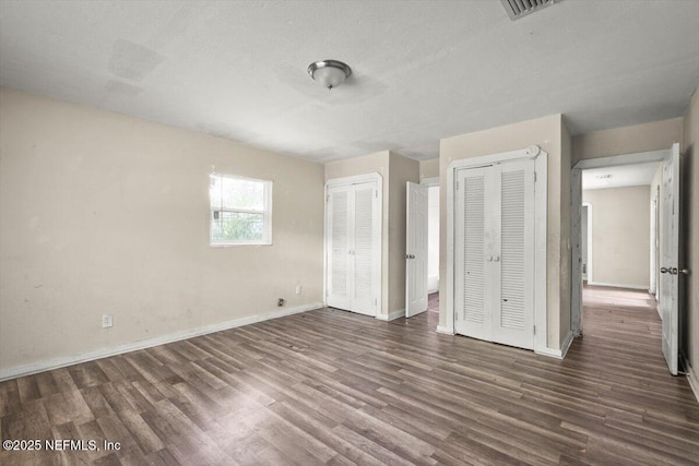 7972 Waxwing Ave, Jacksonville, FL 32219 - unfurnished bedroom with multiple closets, wood finished floors, and baseboards