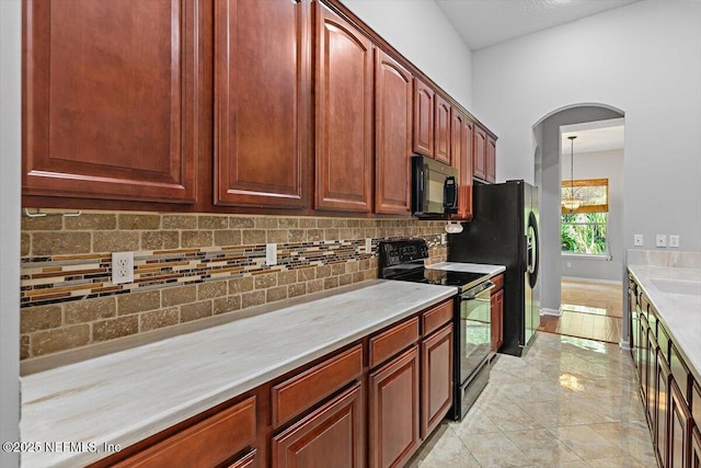 663 Reflection Cove Ct, Jacksonville, FL 32218 - kitchen featuring black appliances, light countertops, tasteful backsplash, arched walkways, and hanging light fixtures