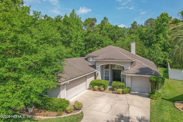 663 Reflection Cove Ct, Jacksonville, FL 32218 - view of front of home with stucco siding, an attached garage, concrete driveway, a front lawn, and a shingled roof